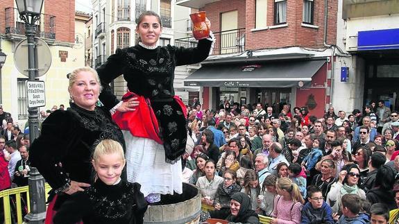 La joven Carmen Ruiz pisa las uvas para el primer mosto en una abarrotada plaza. 