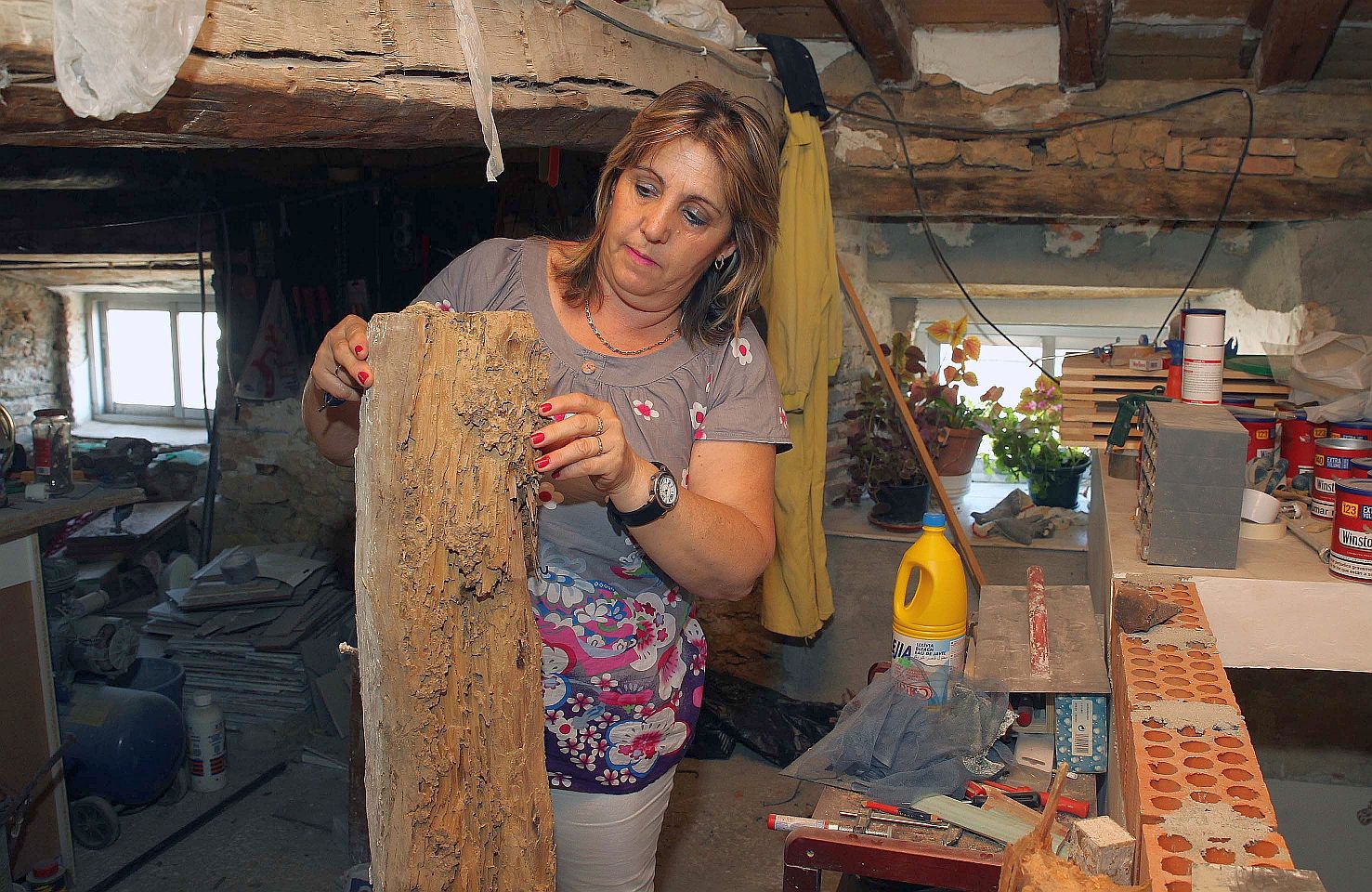 Azucena Llorente, presidenta de la Asociación La Madera, muestra una de las vigas de su casa que ha reemplazado, carcomida por las termitas.