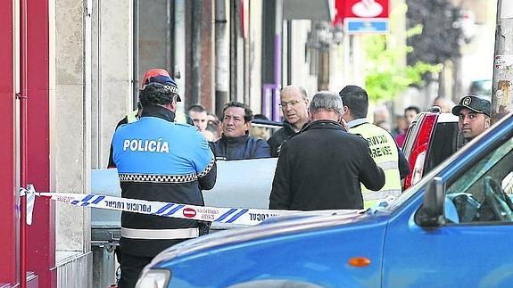 Los servicios funerarios sacan uno de los féretros. 