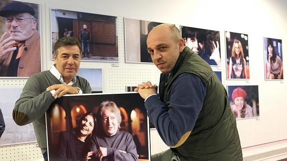 Los fotógrafos Gabriel Villamil y Nacho Gallego posan con uno de los retratos de la exposición.