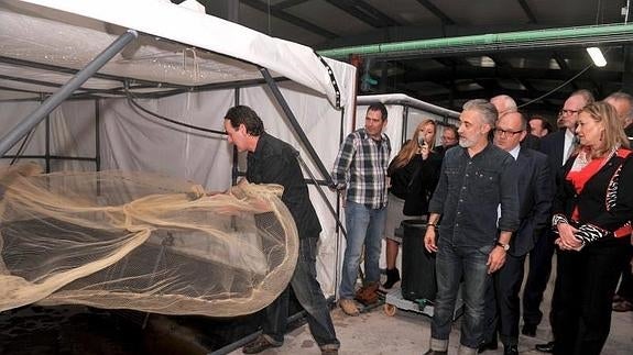 El cocinero Sergi Ariola, la consejera Pilar del Olmo y otros invitados a la inauguración observan la pesca de langostinos en una de las piscinas de Gamba Natural por parte del director técnico, Manuel Poulain. / FRAN JIMÉNEZ 
