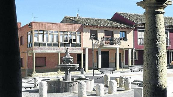 Viviendas y fuente en la plaza de Becerril, a través del porticado.