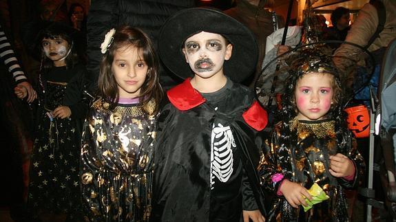 Tres niños con sus disfraces de Halloween. 