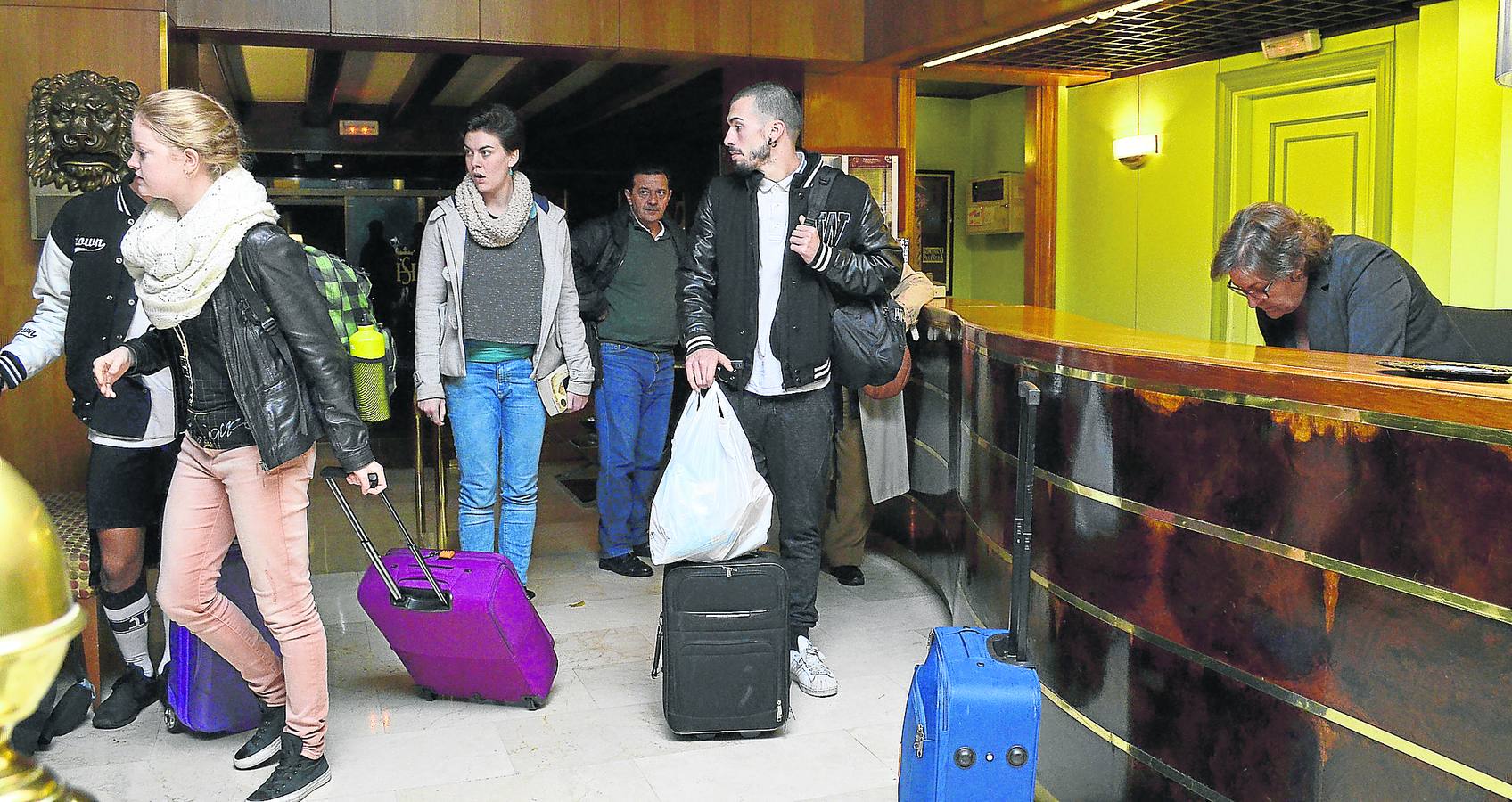 Un grupo de viajeros llegan en la tarde del jueves al vestíbulo del hotel Castilla Vieja para alojarse en el establecimiento. 