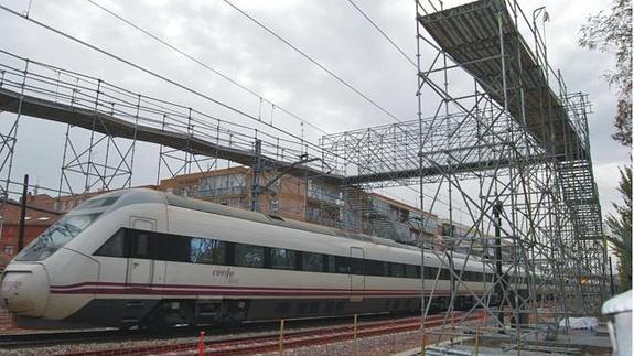 Un tren de alta velocidad pasa bajo la pasarela en construcción en Pilarica.