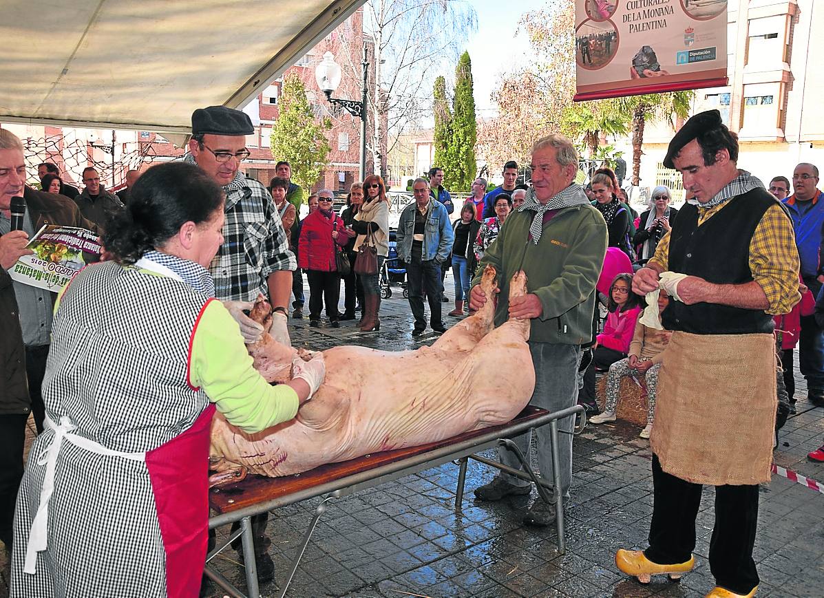 Los matanceros se disponen ayer a abrir el cerdo, ante la curiosidad de los asistentes.