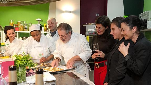 El chef Julio Reoyo es observado por su equipo mientras coloca tapas en una bandeja.