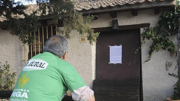 Un hombre mira uno de los carteles que se han distribuido en Barsardilla contra Gómez de la Serna. 