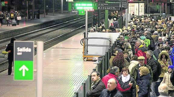 Los pasajeros se agolpan en el andén de la estación de Valladolid a la espera de la llegada del tren.