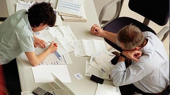 Unos contribuyentes realizan la declaración de la renta. 