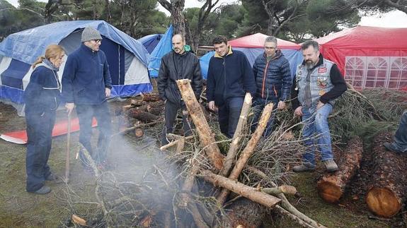 Los integrantes del club Vall’s Riders encienden la primera hoguera en la zona de acampada.