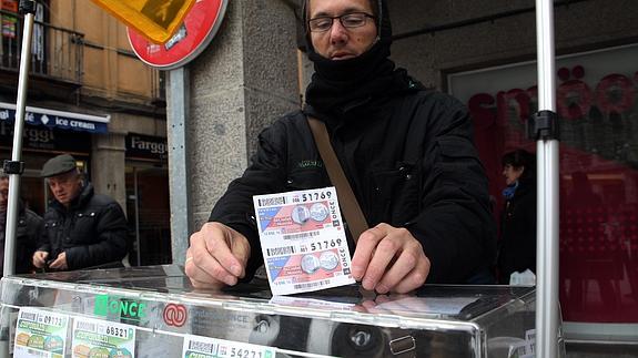 Un vendedor de la ONCE muestra, ayer, dos últimos cupones diarios que le quedaban. 