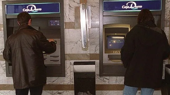Clientes de EspañaDuero sacan dinero de dos cajeros automáticos.