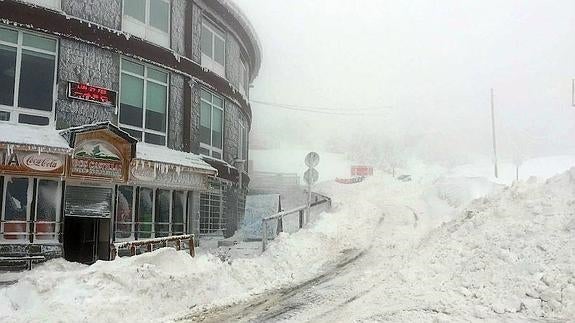 La nieve acumulada en Navacerrada y la escasa visibilidad obligan a conducir con cuidado. 