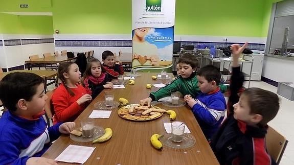 Alumnos del colegio San Gregorio, de Aguilar de Campoo, toman un desayuno variado con leche, fruta y galletas. EL NORTE