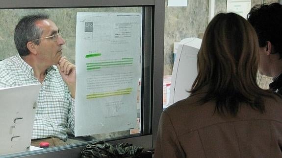 Un funcionario atiende la consulta de unos ciudadanos.