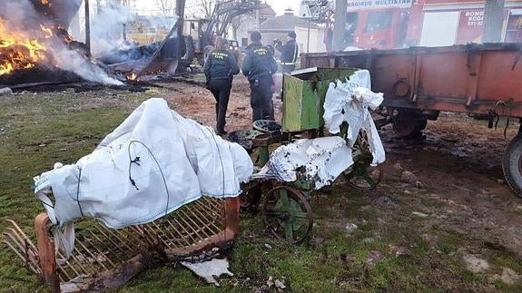 Guardia Civil inspecciona el lugar del incendio mientras los bomberos tratan de sofocar las llamas. 