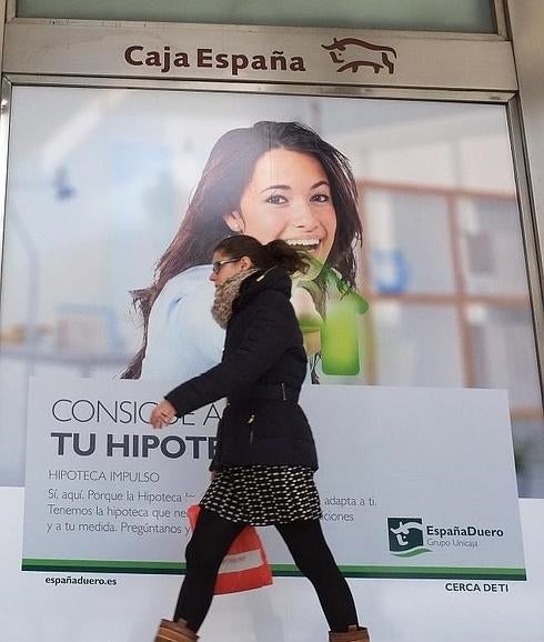 Una mujer pasa frente a un cartel de EspañaDuero.