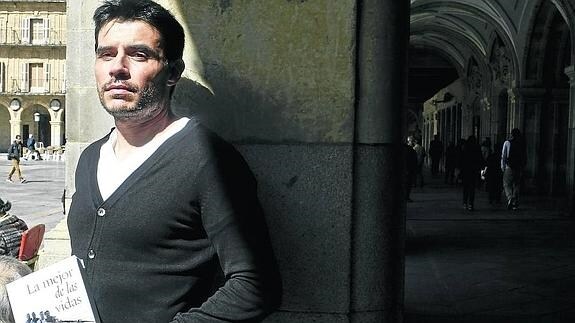 El escritor salmantino David de Juan Marcos posa con su última novela en los soportales de la Plaza Mayor. 