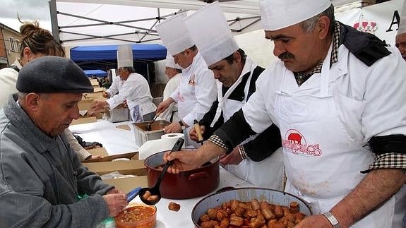 Los cocineros sirven las raciones del chorizo hervido con vino en una anterior edición de la feria. 
