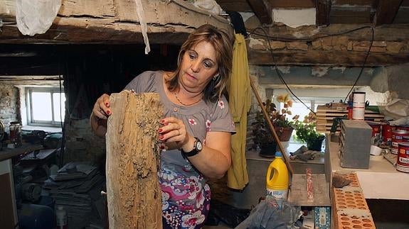Azucena Llorente, presidenta de la Asociación La Madera, muestra una de las vigas de su casa de Carbonero de Ahusín, totalmente carcomida por las termitas. Antonio de Torre