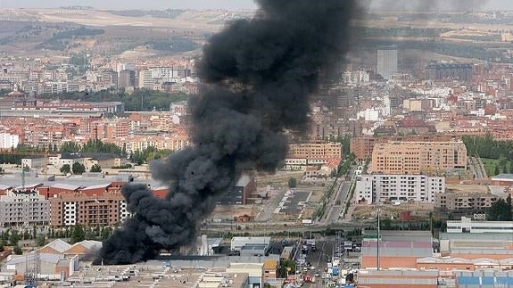 Panorámica de la ciudad mientras el fuego arrasaba las naves de la calle Pirita, en el polígono de San Cristóbal, causando una gran columna de humo visible a varios kilómetros.