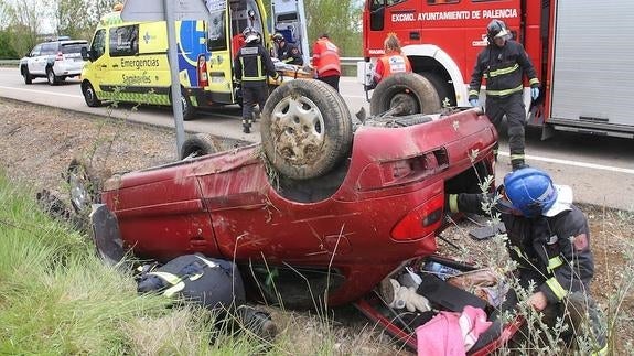 Los bomberos trabajan en el vehículo volcado.