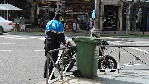 Un agente de la Policía Municipal de Valladolid junto a la motocicleta que conducía el herido.