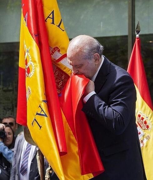 El ministro del Interior besa la bandera. 