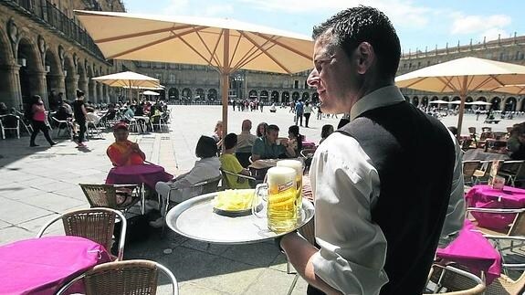 Un camarero sirve unas cañas en una terraza de la Plaza Mayor.