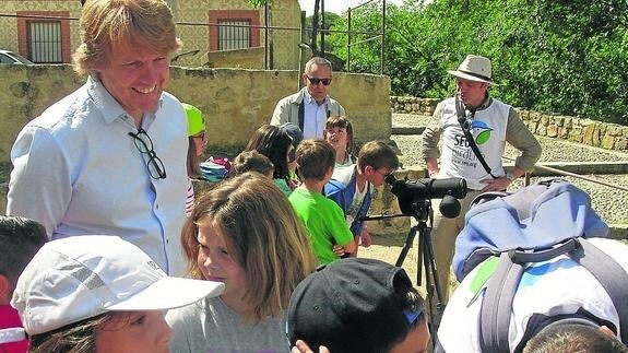 El concejal comenta con niños el desarrollo de una actividad de observación de aves. 