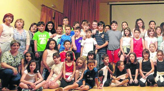La homenajeada, con un ramo de flores en la mano, posa con miembros de la comunidad educativa, entre ellos numerosos alumnos del CRA. 