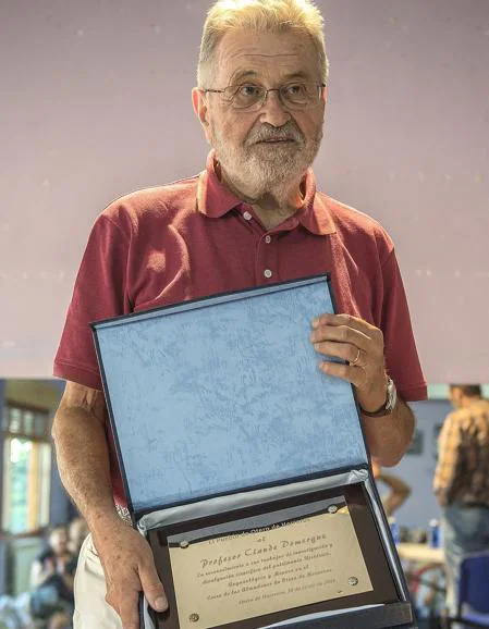 El profesor Claude Domergue muestra la placa.