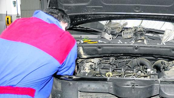 Un mecánico revisa el motor de un vehículo. 