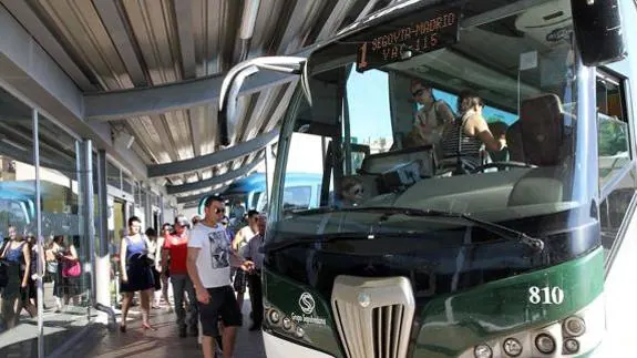 Pasajeros se suben a un autobús para desplazarse a Madrid. El Norte