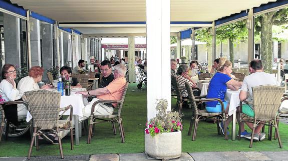 Unos clientes esperan a comer en una terraza del centro de Palencia.