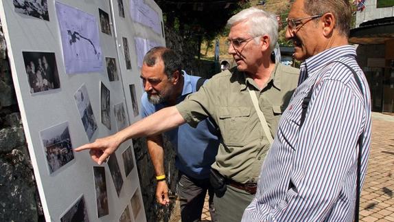 Celebración del 50 aniversario de la apertura al público de la Cueva de Valporquero; en la imagen, tres de los homenajeados miran fotos de la época.