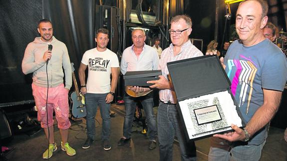 El alcalde, Miguel Ángel de Vicente, muestra la placa entregada por los peñistas, en representación de todos los vecinos. 