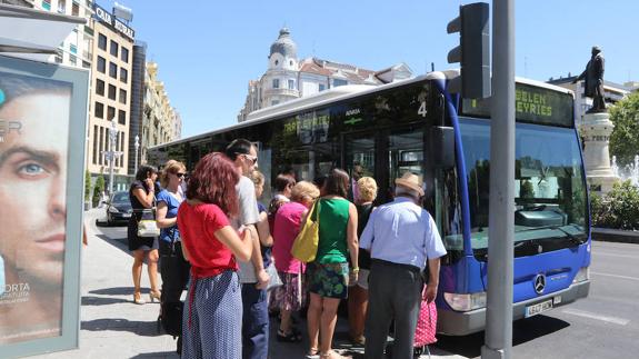 Pasajeros se suben a un autobús en la plaza de Zorrilla. 
