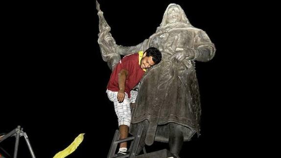 Un peñista retira el pañuelo de la estatua del Conde Ansúrez en unas fiestas pasadas. 