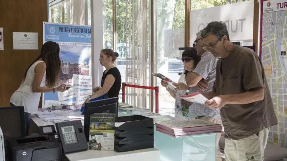 Turistas en Valladolid consultan la oferta y los planos de la ciudad en la Oficina de Turismo situada en la Acera Recoletos.
