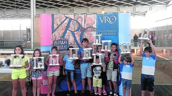 os más pequeños posan con sus trabajos tras el taller celebrado en La Olmeda. 