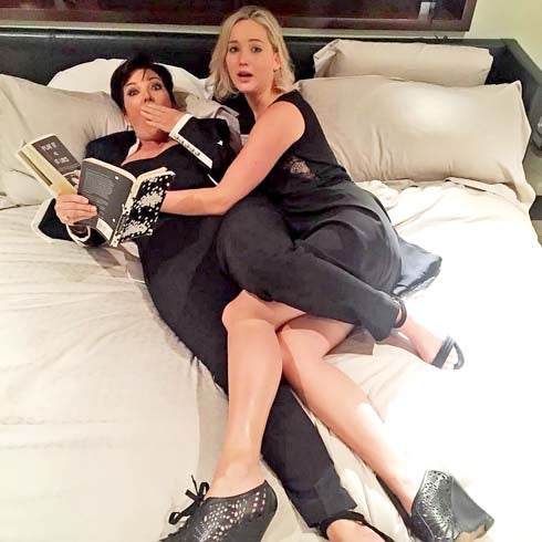 Kris Jenner y Jennifer Lawrence en la cama con cara de sorpresa. 