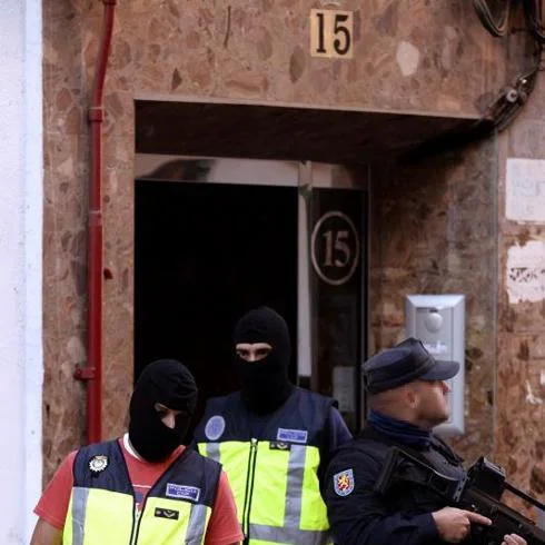 En la imagen efectivos del Cuerpo Nacional de Policía abandonan el domicilio del detenido en Valladolid tras efectuar el registro del mismo