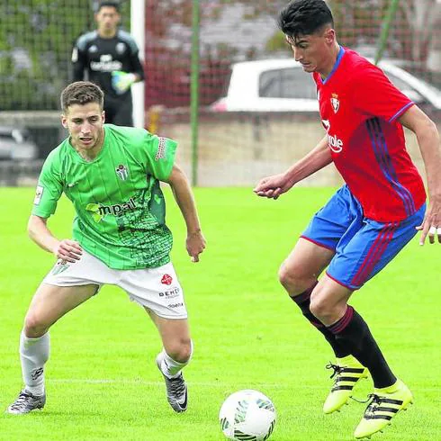 Jonxa, del CD Guijuelo, intenta arrebatar el esférico a un jugador del Osasuna Promesas. 