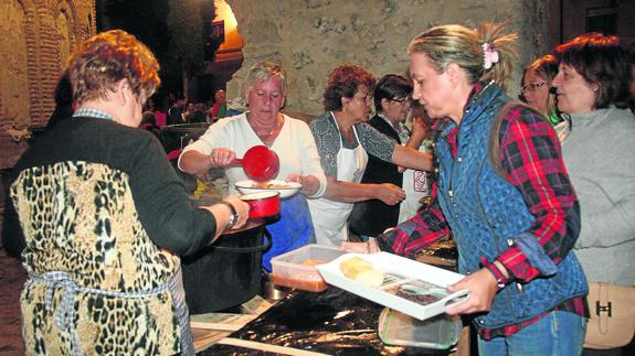 Reparto del guiso de patatas la noche del martes en el atrio de la iglesia de El Salvador. 