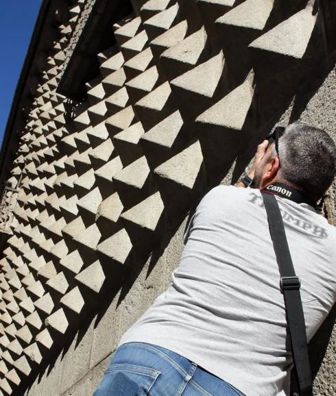 Un turista toma una fotografía de la Casa de los Picos. Antonio de Torre