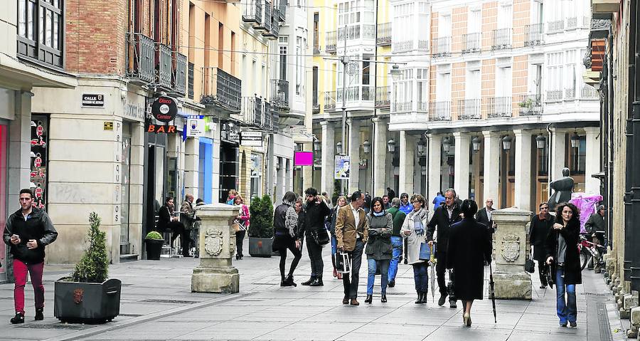 Varias personas pasean por la Calle Mayor. 