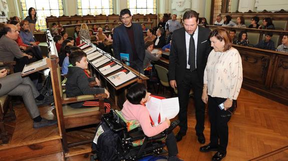 El alcalde y la concejala charlan con uno de los niños.