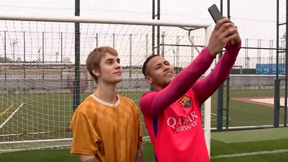Neymar sacándose una fotografía con Bieber. 